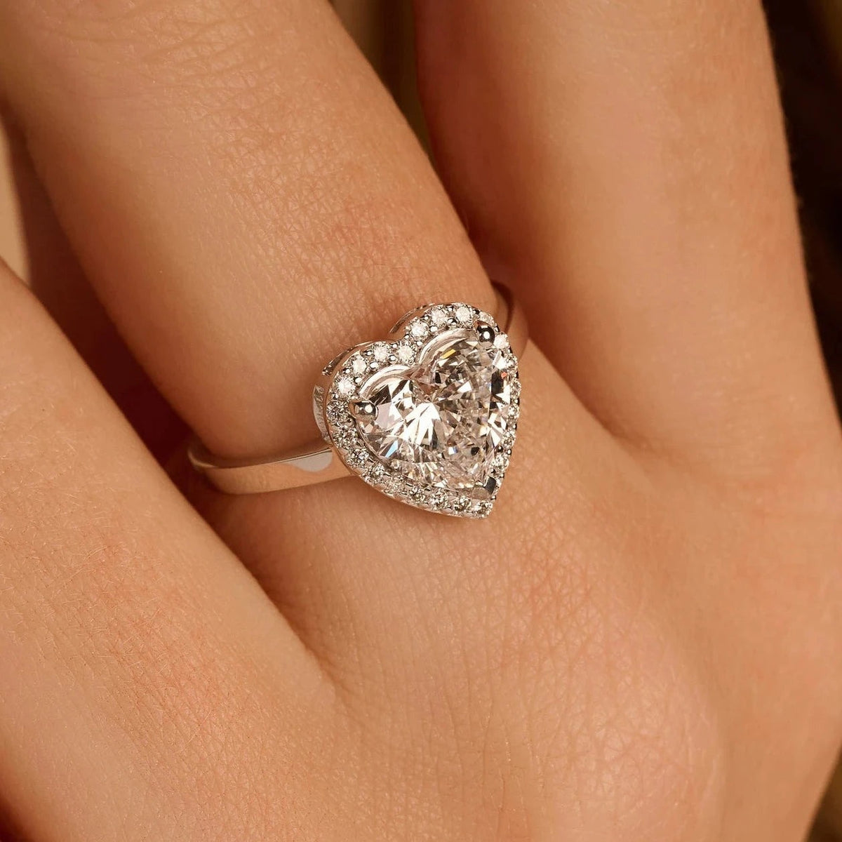 Hartvormige halo verlovingsring 2.5 ct in 14k witgoud aan de hand, op ware grootte (steen 8,5 mm)