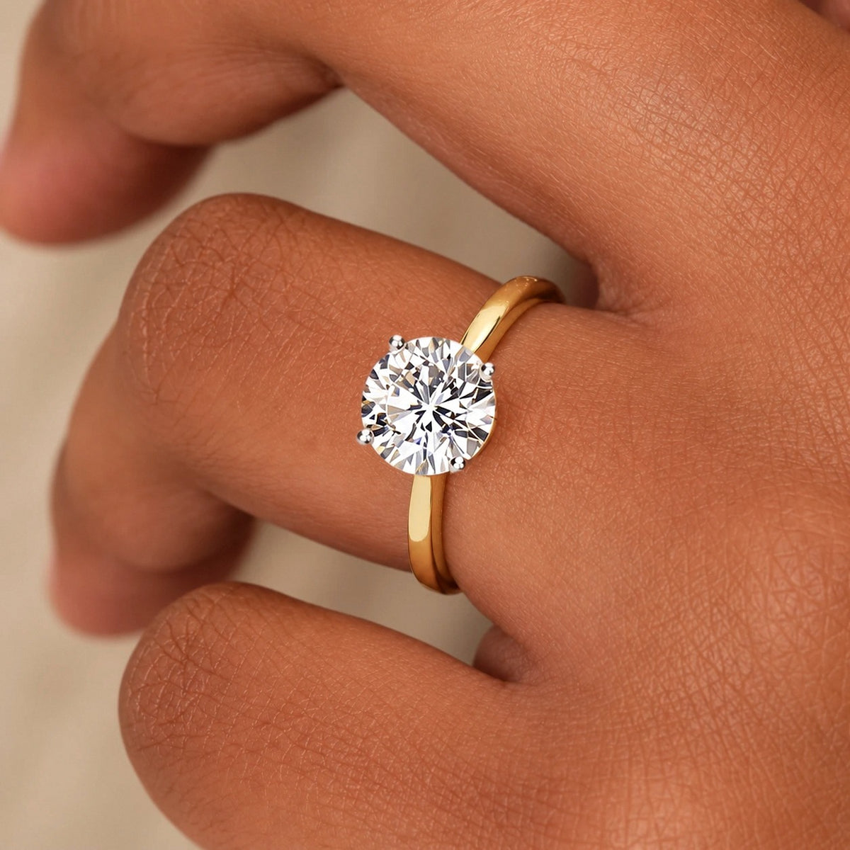 Ronde solitaire verlovingsring 1.5 ct in 14k geelgoud aan de hand, op ware grootte (steen 7,4 mm)
