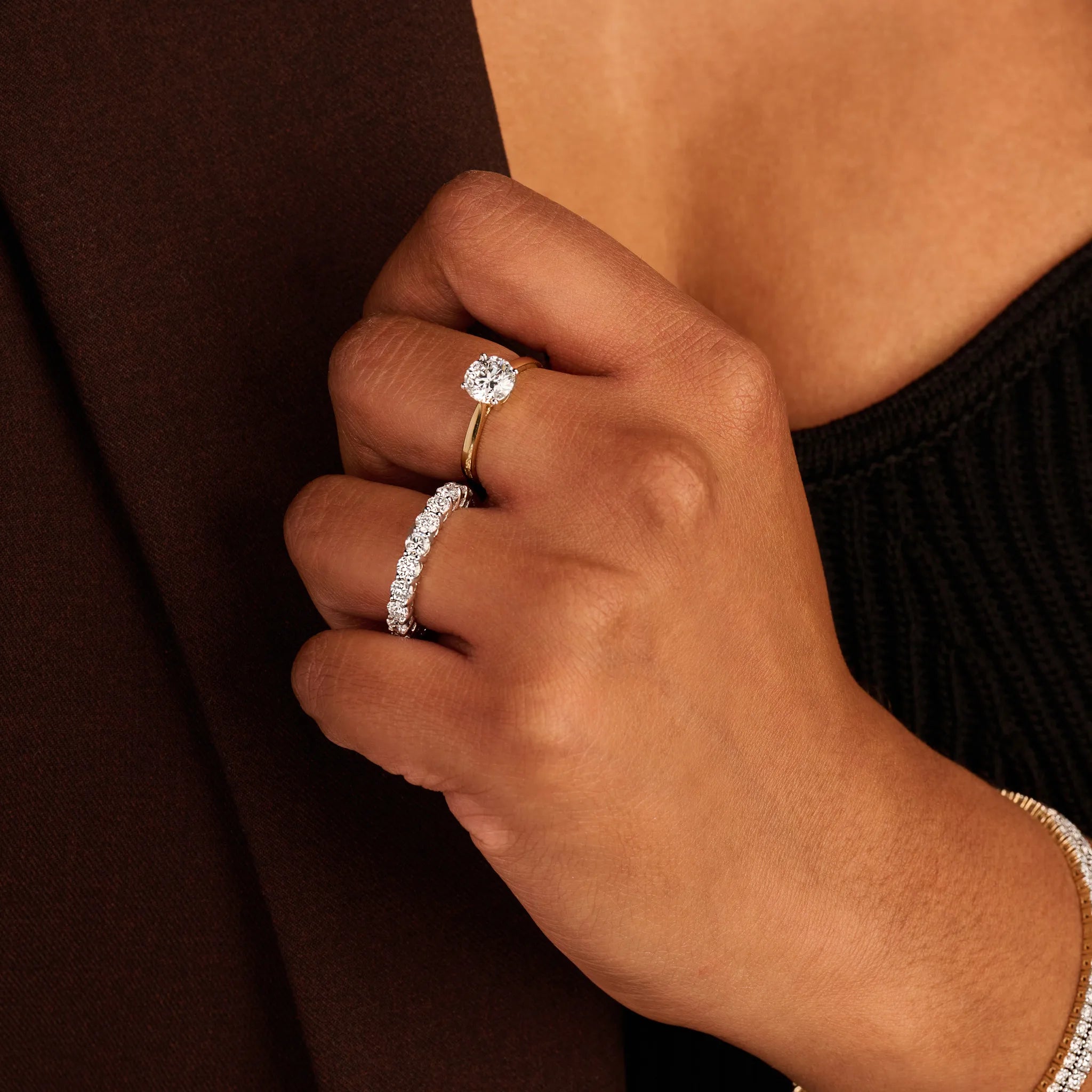 Louen Diamonds solitair ring van 14k geelgoud en 1.5ct diamant op model met ook tennisarmbanden en een solitaire collier op donkere kleding