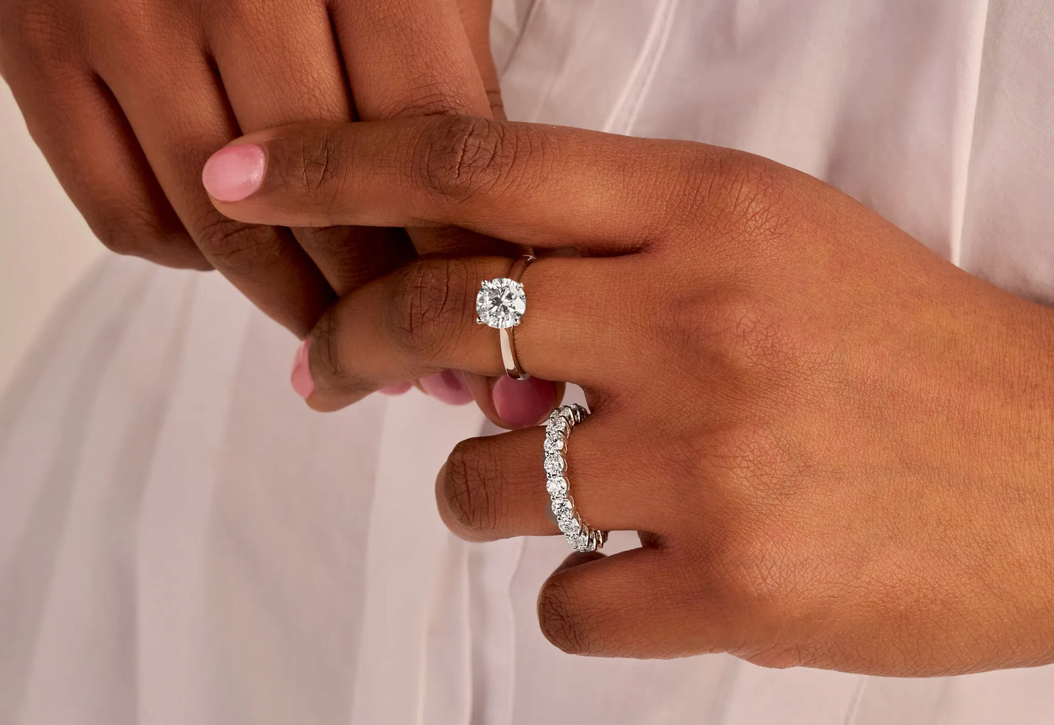 Louen Diamonds solitaire ring en eeuwigheidsring samen op de hand van een model met 2.0 en 3.0 ct diamanten