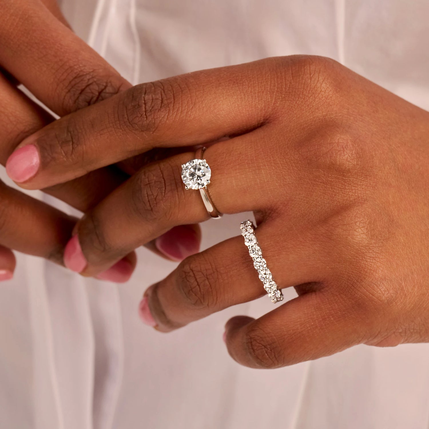 Louen Diamonds solitaire ring en eeuwigheidsring samen op de hand van een model met 2.0 en 3.0 ct diamanten