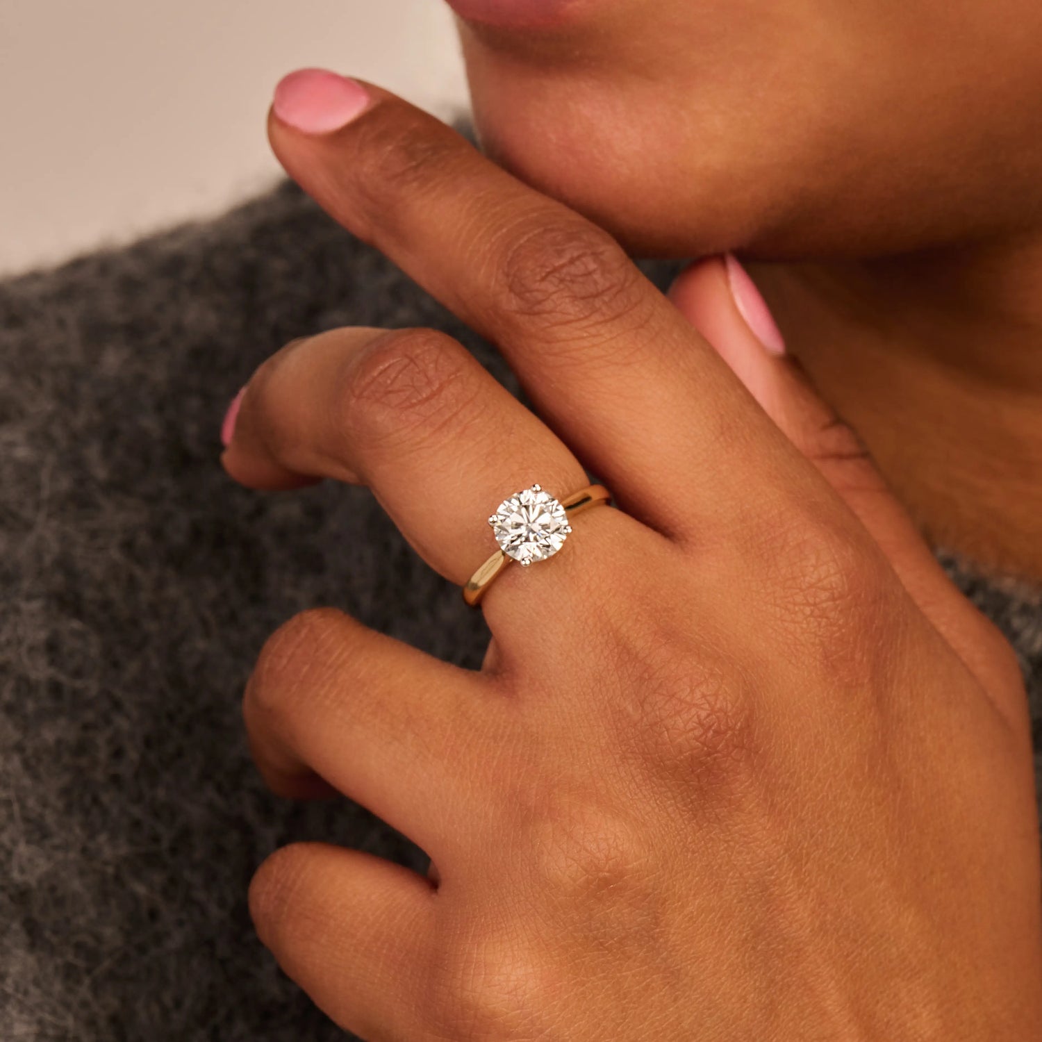 Louen Diamonds solitaire ring van 14k geelgoud met een 2.0ct diamant op model in volle trui close up