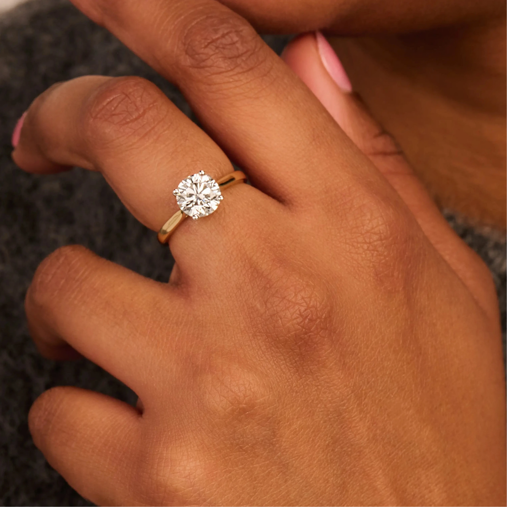 Louen Diamonds solitaire ring van 14k geelgoud met een 2.0ct diamant op model in volle trui close up