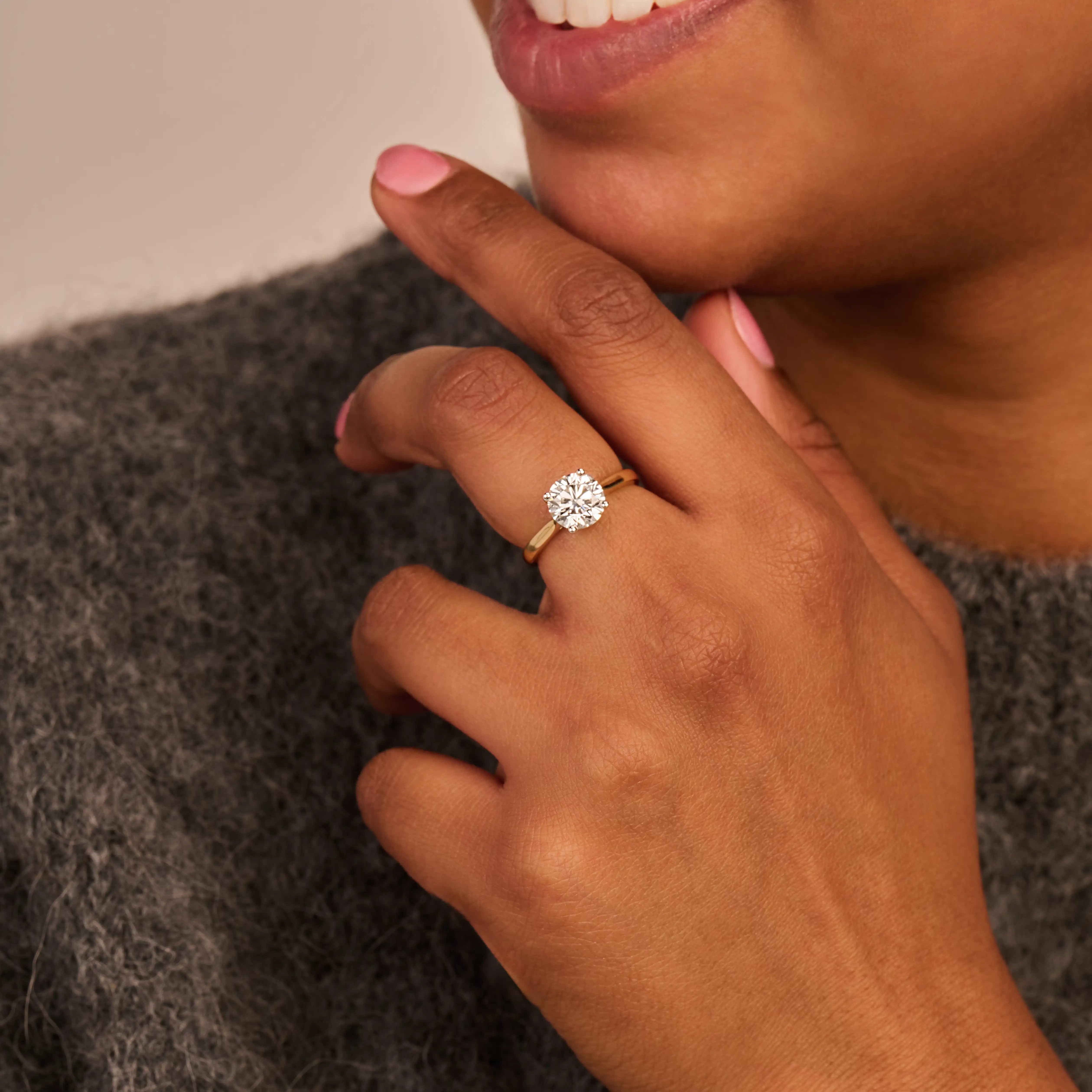 Louen Diamonds solitaire ring van 14k geelgoud met een 2.0ct diamant op model in volle trui close up