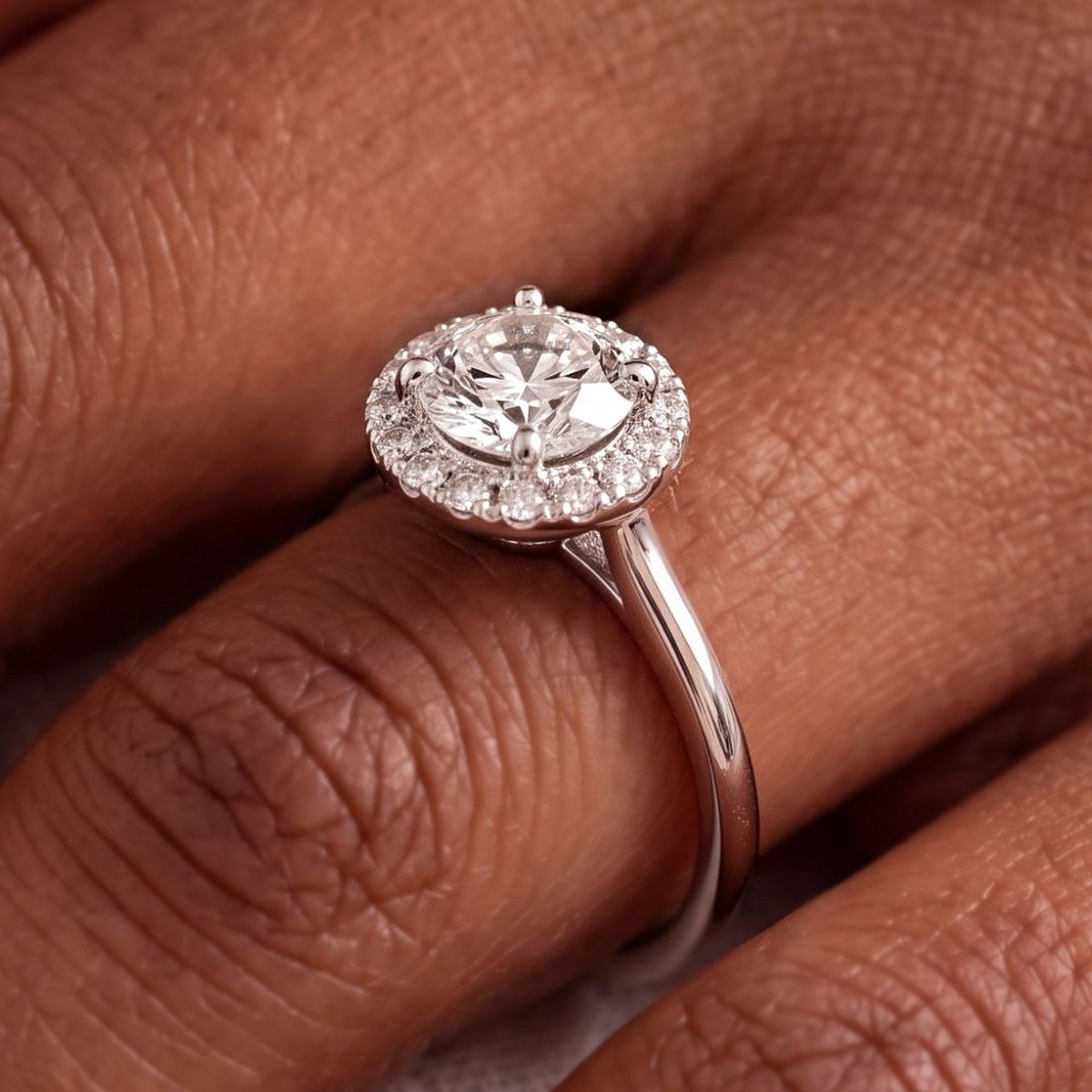 Close-up van de ronde halo verlovingsring 1.75 ct in 14k witgoud aan de hand