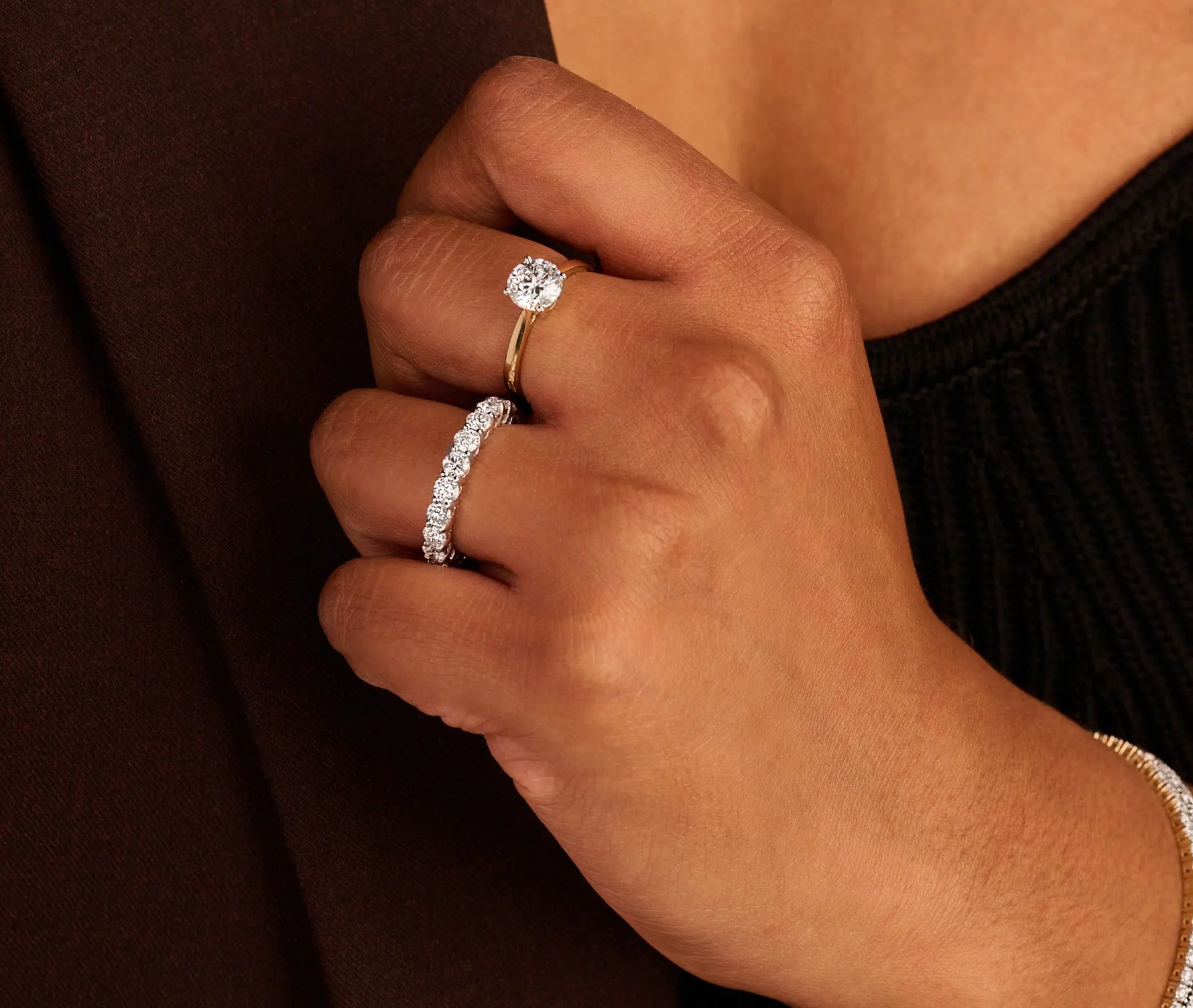 Louen Diamonds solitair ring van 14k geelgoud en 1.5ct diamant op model met ook tennisarmbanden en een solitaire collier op donkere kleding super close up