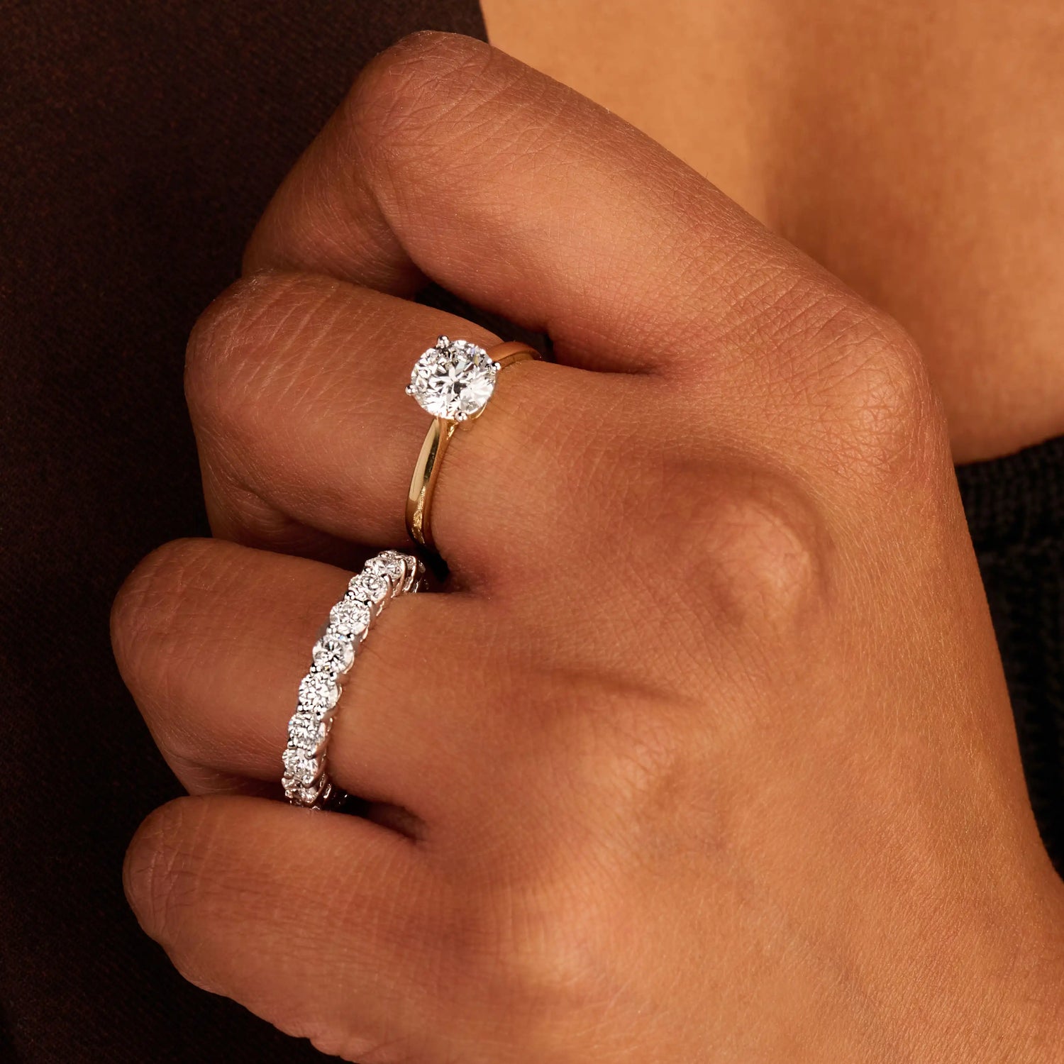 Louen Diamonds solitair ring van 14k geelgoud en 1.5ct diamant op model met ook tennisarmbanden en een solitaire collier op donkere kleding super zoom