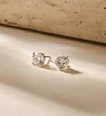 Louen Diamonds solitaire oorstekers 4 pins 14k witgoud met 2.5ct diamant in totaal als sfeerbeeld op zachte achtergrond