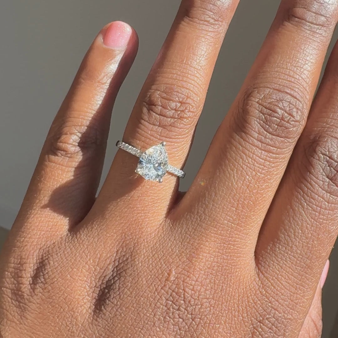 Peervormige solitaire verlovingsring met pavé band 2.0 ct witgoud aan de hand