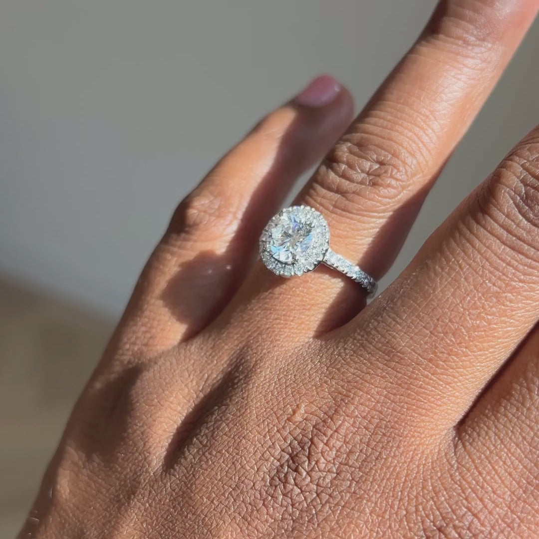 Ronde halo verlovingsring met pavé band 1.5 ct witgoud aan de hand
